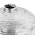 Close-up of the vase's open circular neck and curved shoulder, showing mottled pale areas, dark speckles and bright silver texture.