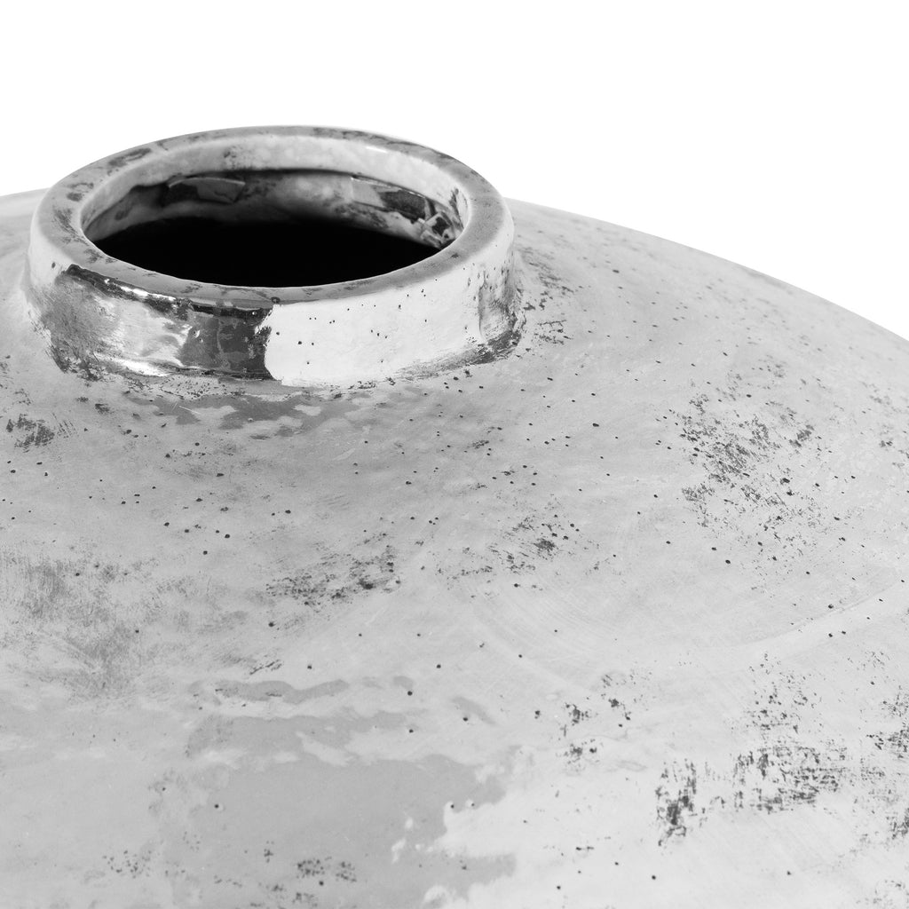 Close-up of the vase opening and curved shoulder, showing reflective silver patches and cloudy white markings.