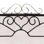 Close-up of the fire screen's silver-toned scroll crest above a black heart motif and fine diamond-patterned mesh.