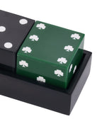 Close-up of the glossy green die with white shamrocks, beside part of the black dot die in the black tray.