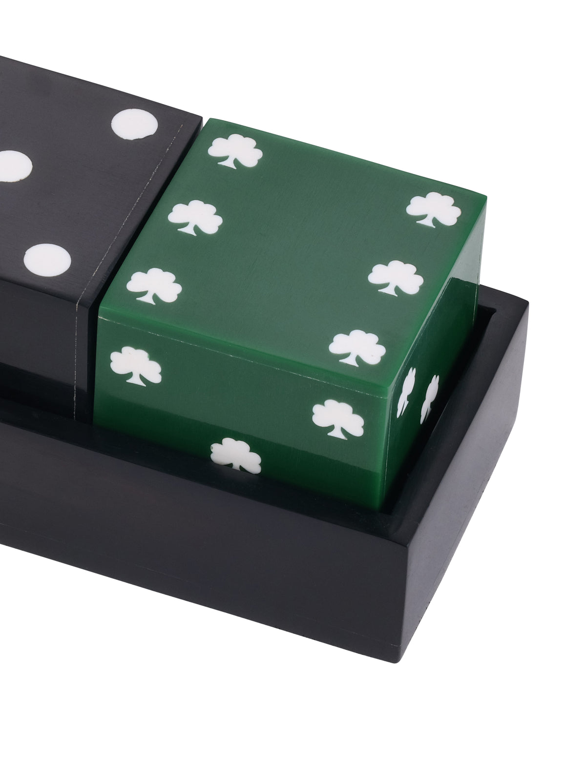 Close-up of the glossy green die with white shamrocks, beside part of the black dot die in the black tray.