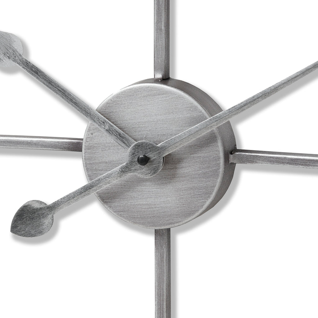 Close-up of the clock's circular centre and overlapping hands, showing fine rubbed-looking marks in the silver-toned surface.