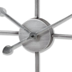 Close-up of the clock's circular centre and overlapping hands, showing fine rubbed-looking marks in the silver-toned surface.