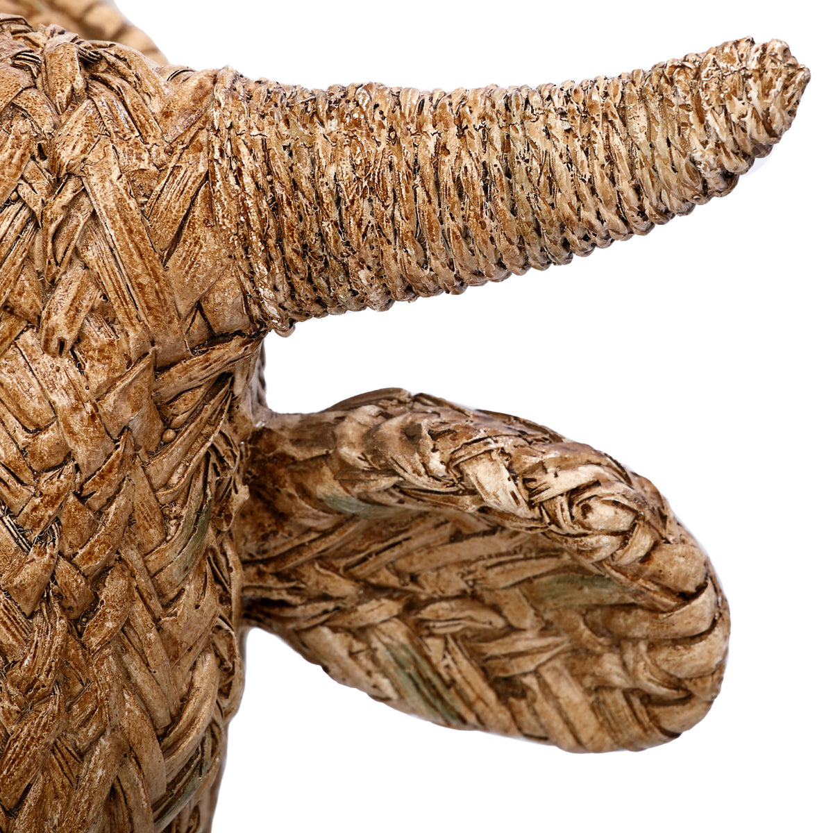 Close-up of a ridged horn and broad ear, showing pale highlights, dark grooves and woven-effect detailing.