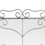 Close-up of the fire screen's curved top crest and mirrored scrolls over fine diamond-pattern mesh.
