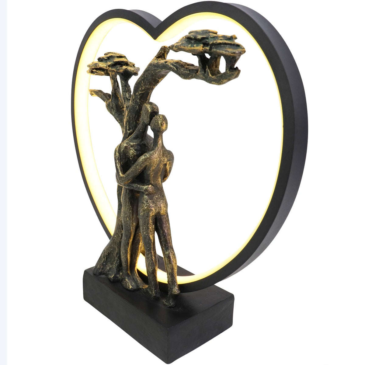 Angled view of the illuminated sculpture showing the depth of the heart frame, tree and embracing figures.