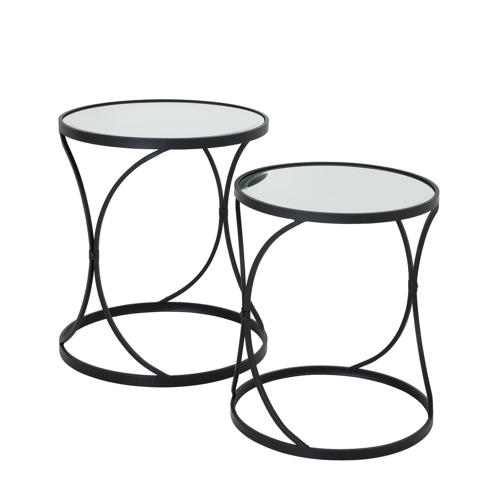Two round side tables with mirrored tops and black curved frames, with the taller table behind and to the left.