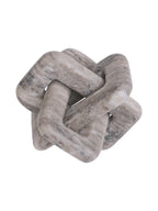 Side view of the marble knot sculpture showing overlapping loops and the open spaces between them.