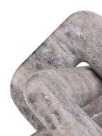 Close-up of a rounded corner and crossing loops, showing pale beige marble with darker flecks and markings.