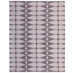 Full view of the rug's reverse, with ivory interlocking shapes and diamonds against a grey background.