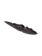 Angled view into the elongated dish, showing its textured dark interior, tapered ends and irregular organic edge.
