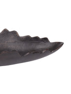 Close-up of the dish interior and side, showing the grainy antique black finish and bronze-toned accents along the uneven rim.