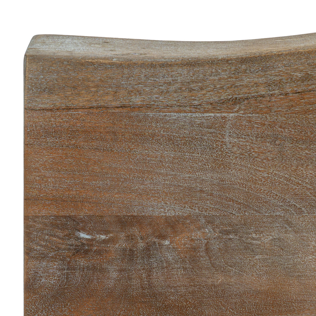 Close-up of the tabletop's brown grain and pale surface highlights, with a gently curved edge along the top of the image.