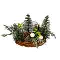 Candle wreath with an empty clear central vessel, dark green bottle-brush trees, ivory berries, pinecones and grey-green foliage on a brown twig ring, against a white background.
