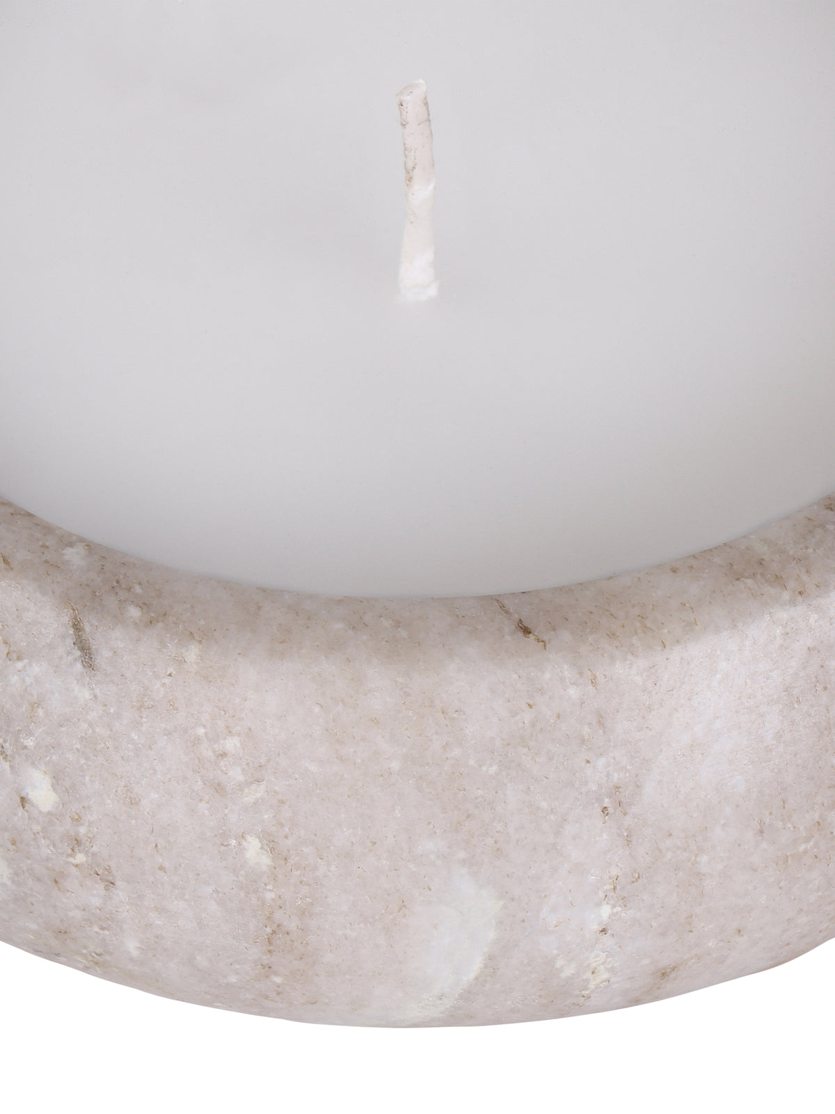 Close-up of the candle's curved marble front and rounded rim beneath the white wax surface and unlit wick.