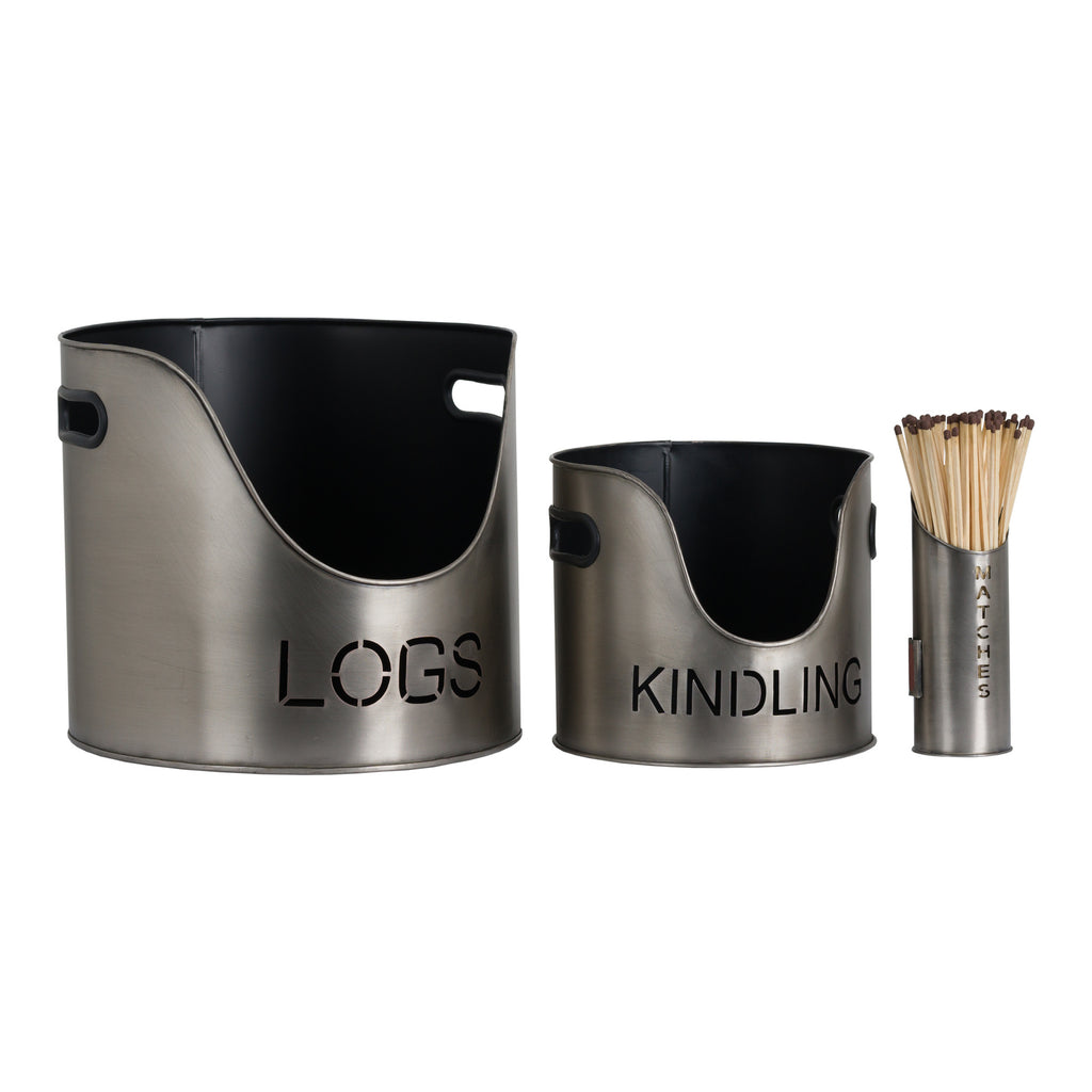 Pewter-colour LOGS and KINDLING buckets with black interiors and side handles, beside a MATCHES holder styled with matches on a white background.