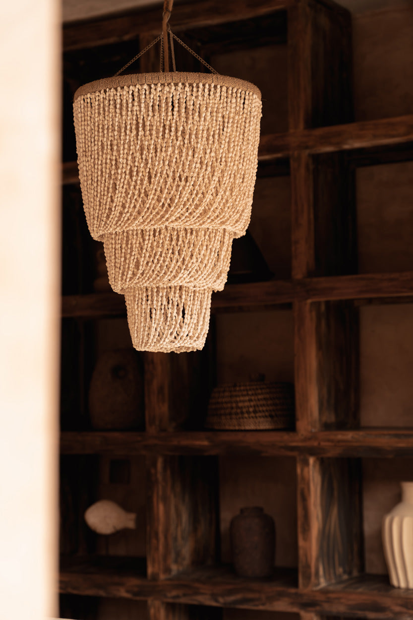 Lagoon Shell Chandelier – Natural, Medium — styled in a dark shelving interior