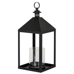 Three-quarter view of a black lantern with a rectangular frame, clear cylindrical insert, sloping roof and circular top ring.