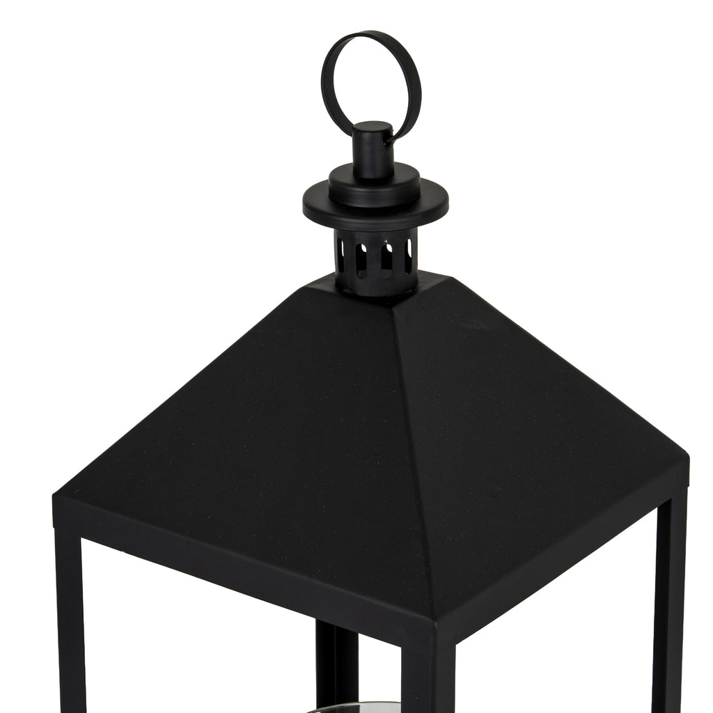 Close view of the lantern's black roof-shaped top and circular ring, with the upper frame visible below.