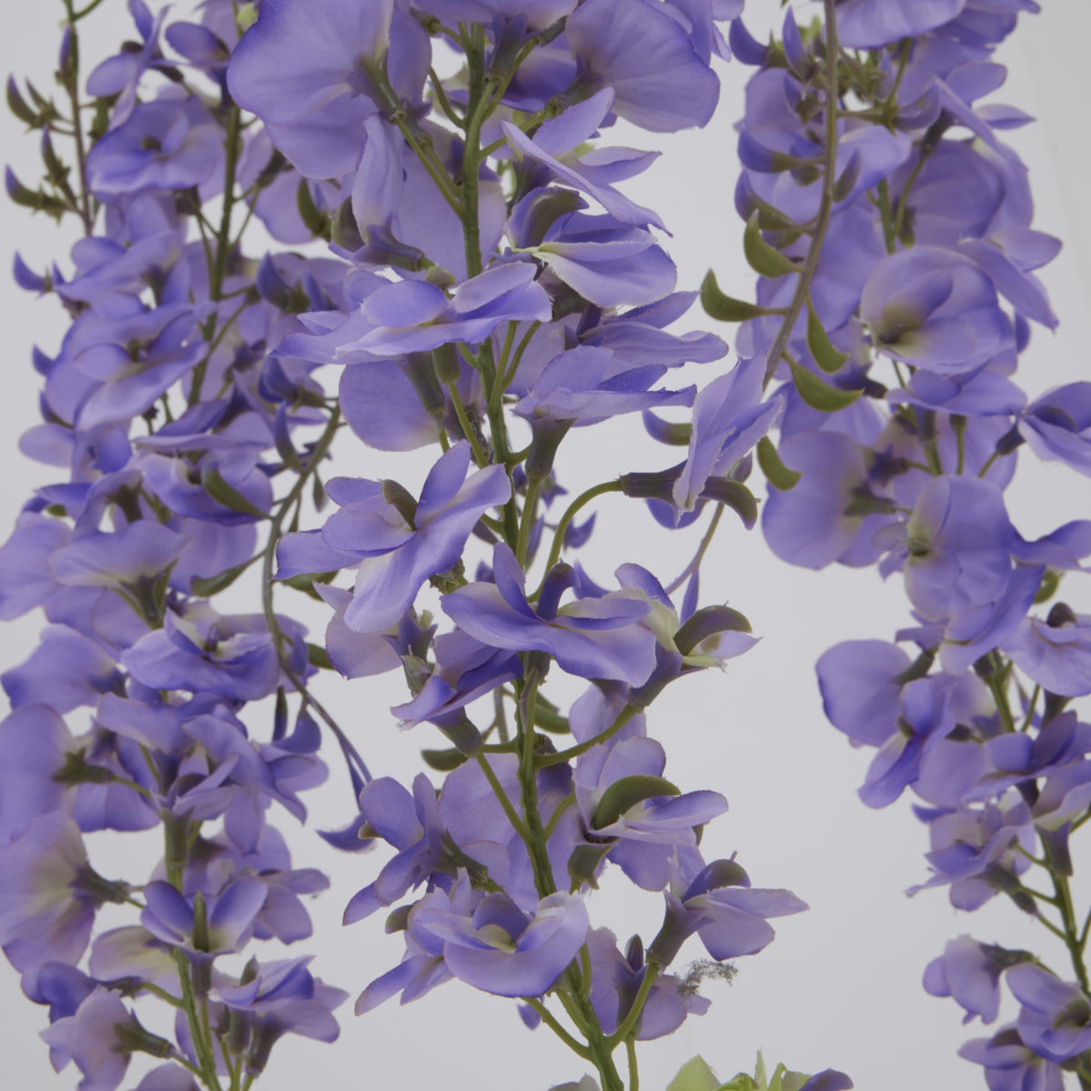 Close-up of lavender-purple artificial flowers with overlapping curved petals along slender green stems.