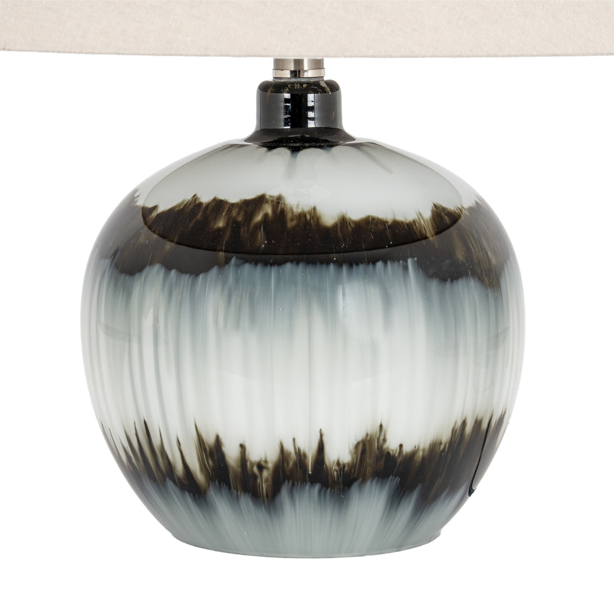 Close view of the rounded lamp base, showing glossy reflections, feathered dark bands and vertical streaks through pale grey-white areas.