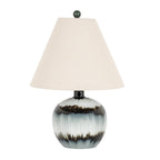 Table lamp with an off-white tapered shade, dark spherical finial and rounded glossy base patterned with pale areas and smoky bands.