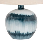 Close-up of the glossy rounded lamp base showing feathered dark teal bands and pale vertical blue streaks beneath the shade