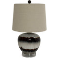 Table lamp with a broad beige shade, dark spherical finial and glossy rounded base patterned with brown bands on a clear stepped foot
