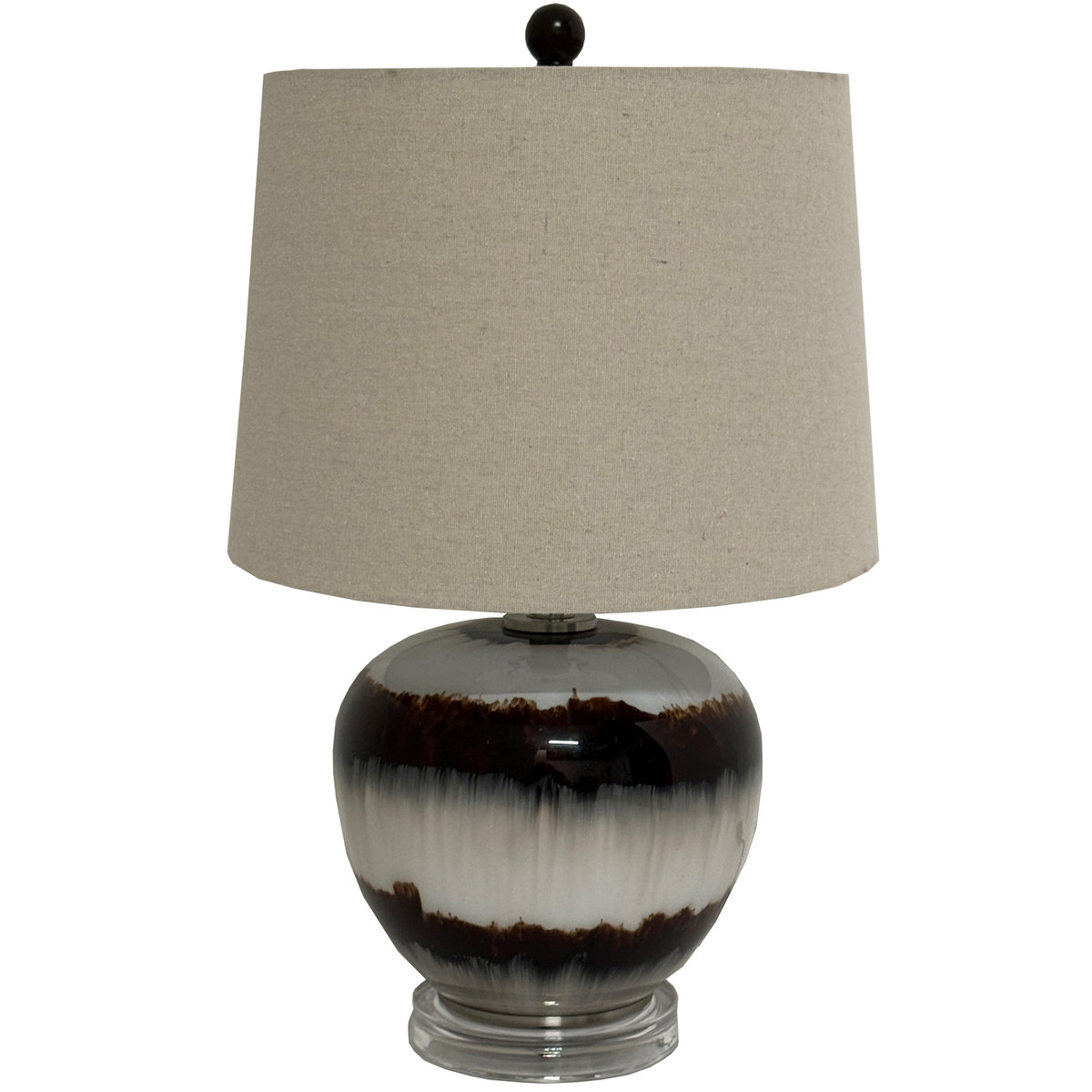 Table lamp with a broad beige shade, dark spherical finial and glossy rounded base patterned with brown bands on a clear stepped foot