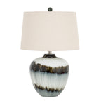 Table lamp with a pale glossy rounded base, two irregular dark bands, an off-white tapered shade and a dark ball finial against white.