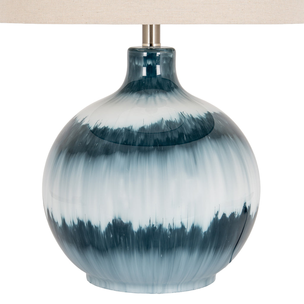 Close-up of the lamp's glossy blue body, showing feathered dark teal bands, pale translucent areas and fine vertical streaks beneath the shade.