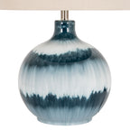 Close-up of the lamp's glossy blue body, showing feathered dark teal bands, pale translucent areas and fine vertical streaks beneath the shade.