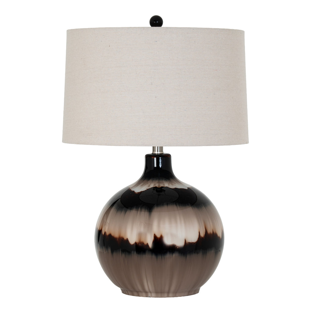Table lamp on white with a glossy rounded taupe, cream and near-black banded body, pale tapered shade and dark ball finial.