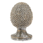 Upright oval pinecone ornament with grey-white layered scales and golden highlights on a wide, flared circular pedestal.