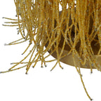 Close-up of loose amber bead strands with small metal end loops hanging around the lamp's gold-coloured base.
