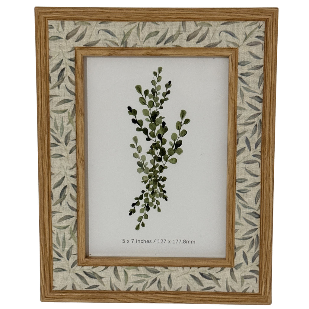 Front view of the Leafprint Doubletrim photo frame with warm wood-tone edges, a pale leaf-patterned border and a botanical insert marked 5 × 7 inches.