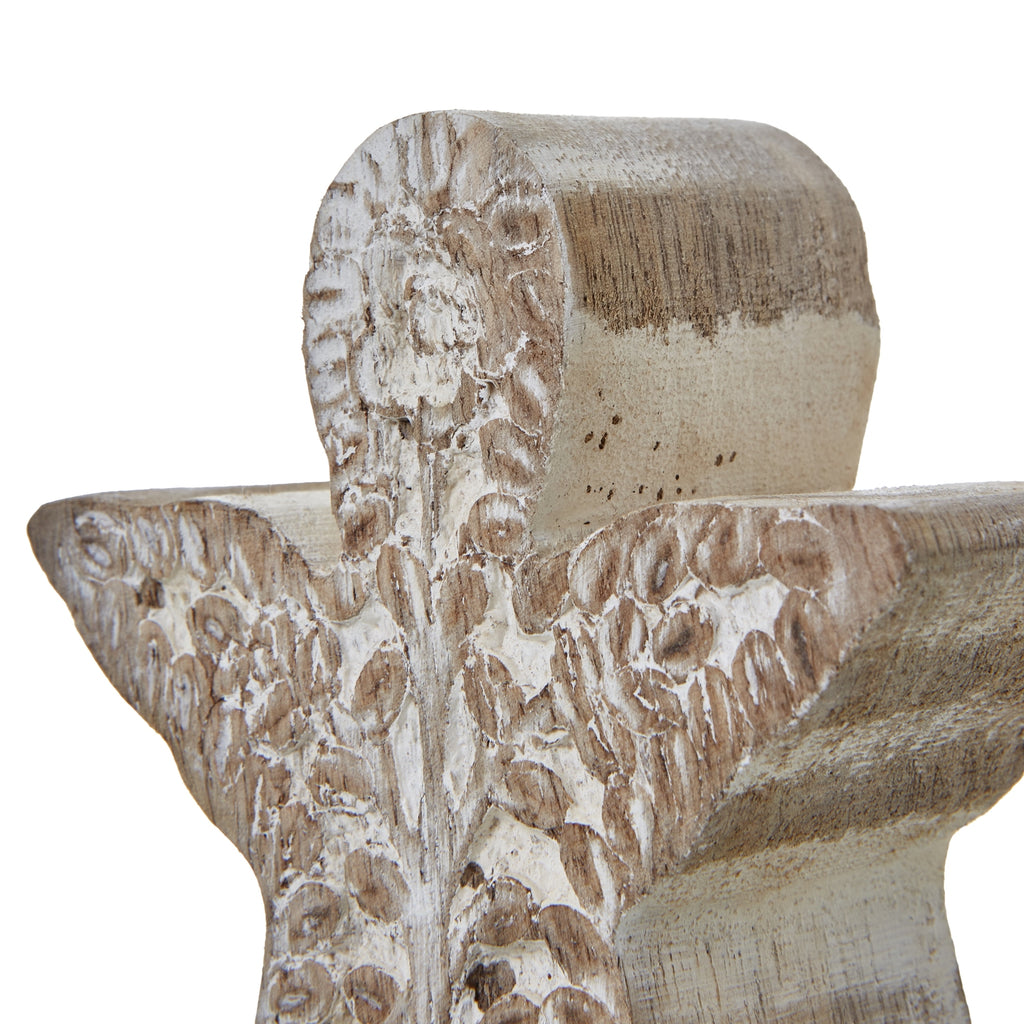Close-up of the angel's rounded head and outspread wings, with distressed white wash around the floral and leaf relief.