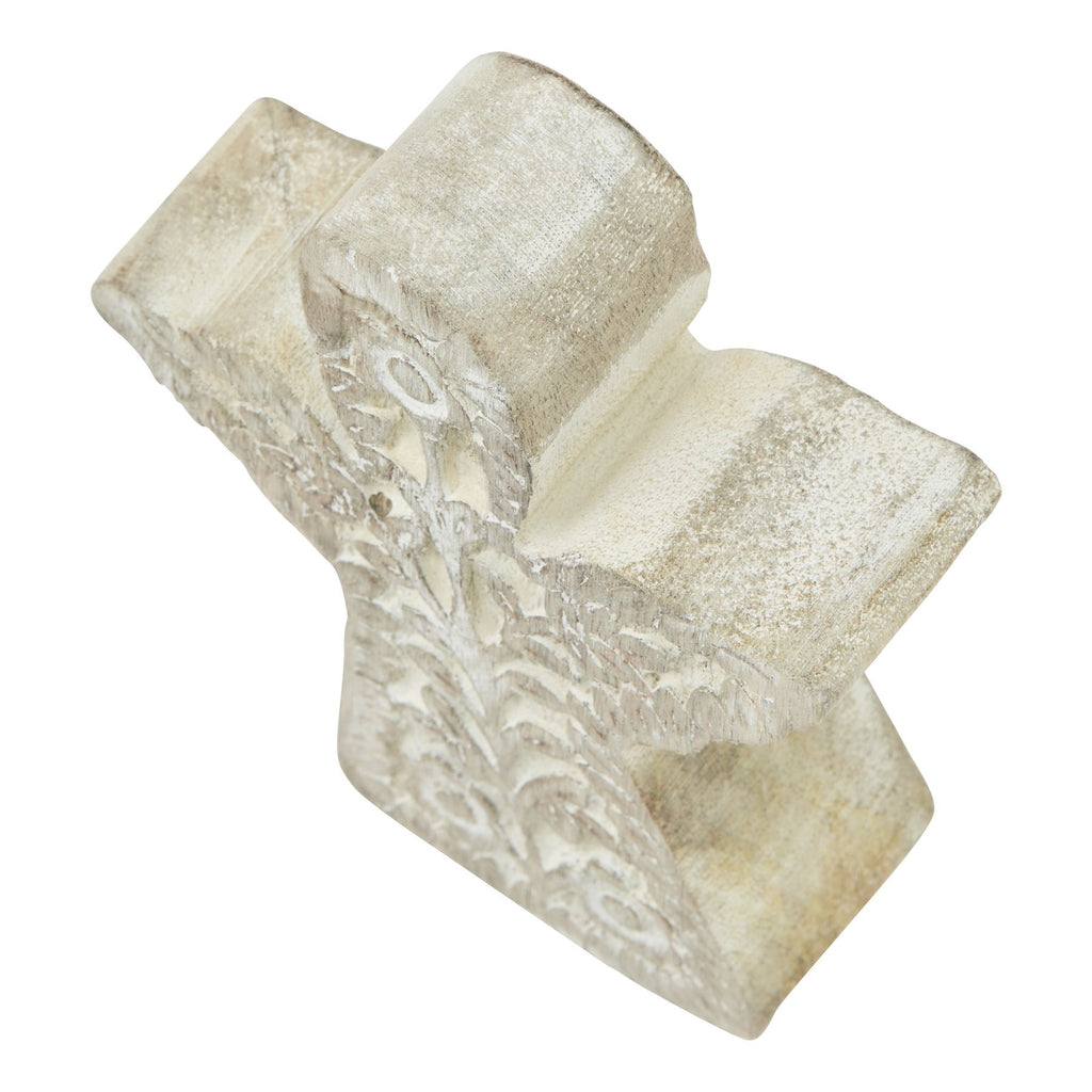 Angel decoration viewed from above, showing the thick rounded head, wing edges and pale textured finish.