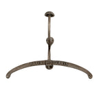 Front view of an antiqued-silver-tone garment hanger with a broad curved rail, raised HOTEL de PARIS lettering and a tall dome-capped hook.