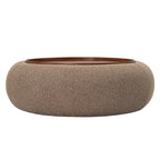 Low front view of the round coffee-coloured ottoman with textured upholstery and an inset walnut-toned tray.