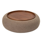 Elevated view showing the circular tray and its raised rim within the curved upholstered ottoman.