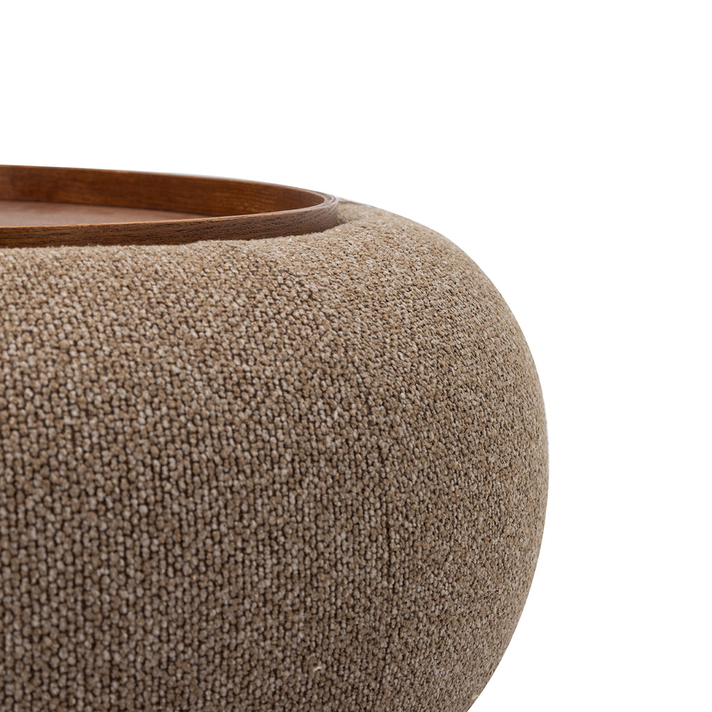 Close-up of the coffee-coloured chenille texture, curved upholstery and walnut-toned tray edge.
