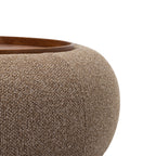 Close-up of the coffee-coloured chenille texture, curved upholstery and walnut-toned tray edge.