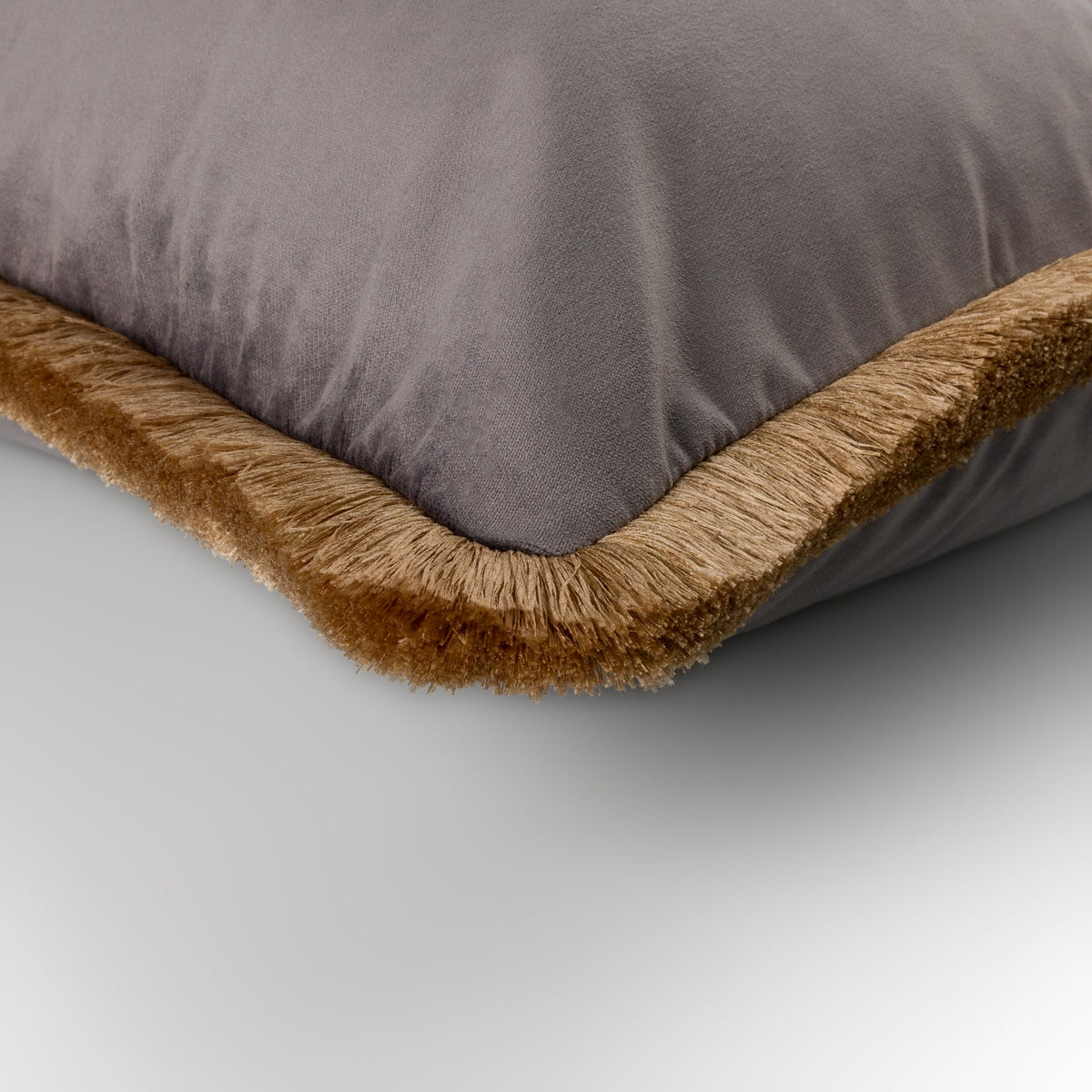 Close-up of the grey velvet Liora Cushion with gold fringe