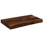 Angled view of a thick brown chopping board showing its flat rectangular top, straight sides and irregular live front edge against white.