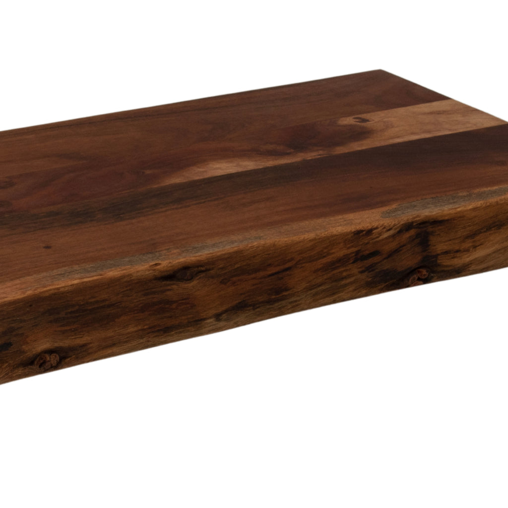 Close-up of the chopping board's front edge, showing dark textured markings beneath a flat top with contrasting light and deep brown grain.
