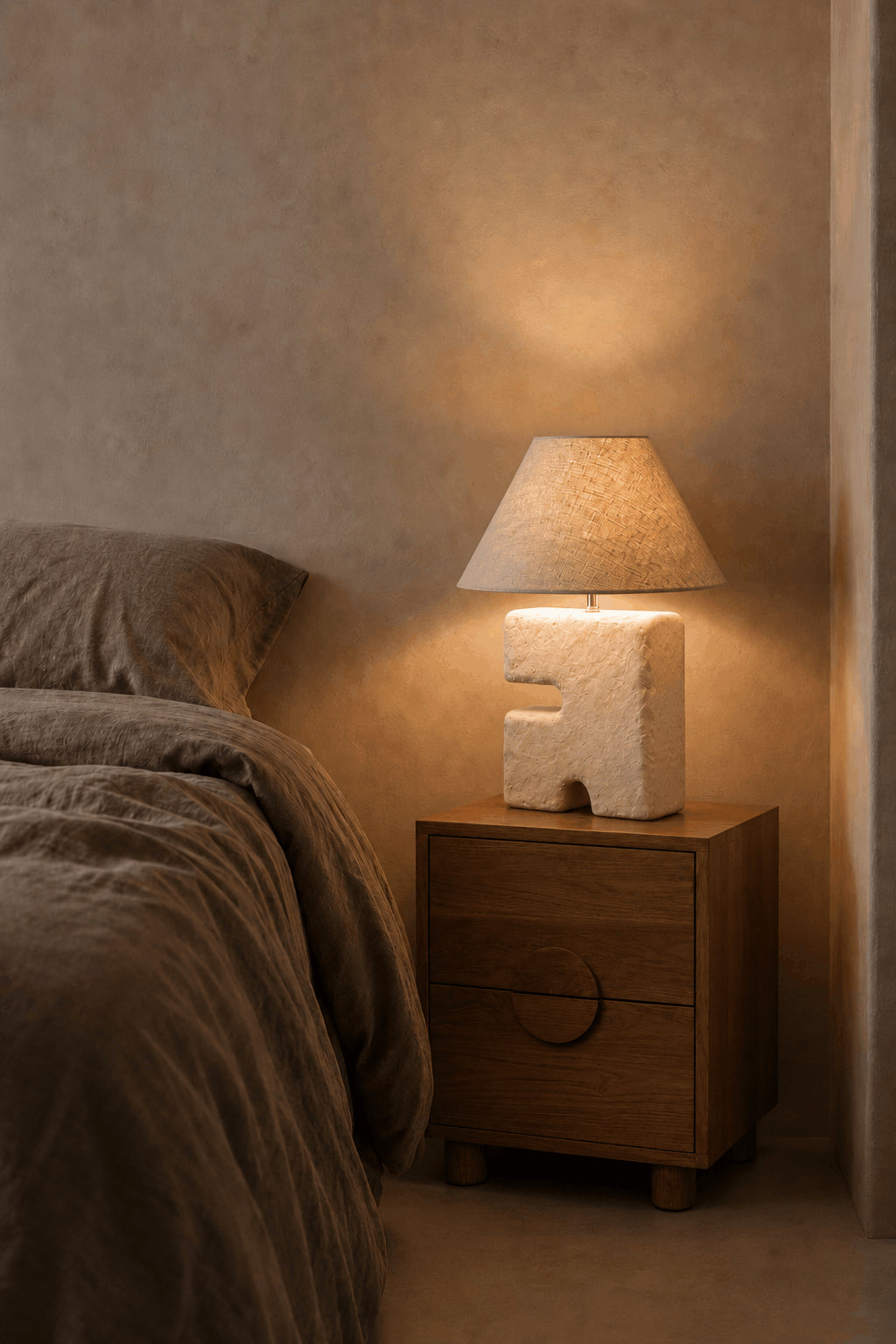 L’Objet Papier-Mâché Table Lamp – White, Medium — lit beside a bed