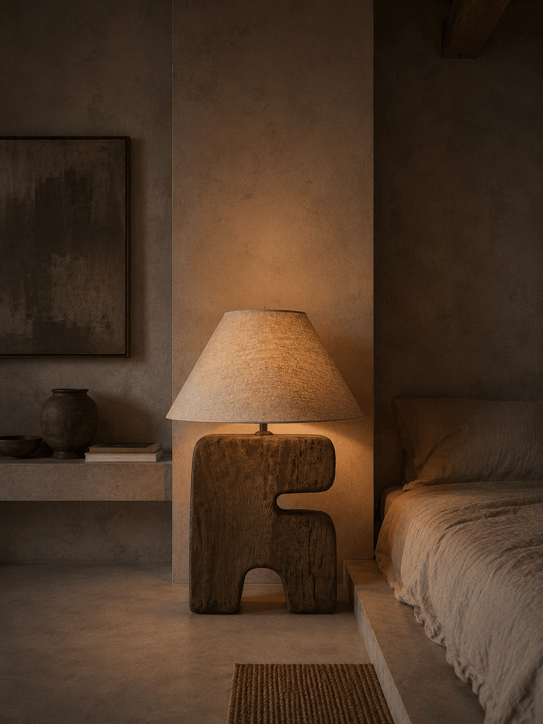 L’Objet Wooden Table Lamp – Brown, Large — lit beside a bed