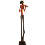 Full-length violinist figurine on a dark rectangular plinth, with very long dark trousers, a red shirt, yellow tie and tall dark hat, against white.