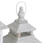 Close-up of a pale loop surrounding a turned finial above the lantern's tiered roof and open upper section.